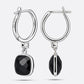 Rear and side views of the earrings, showing the RILAVE and 925 engravings inside one hoop and the black garnet in profile.