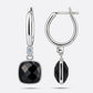 Front and side views of the silver drop hoop earrings, showing the black garnet's faceted face and the depth of its setting.