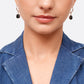 Front view of a model wearing both sterling silver drop hoop earrings, each finished with a faceted black garnet drop.