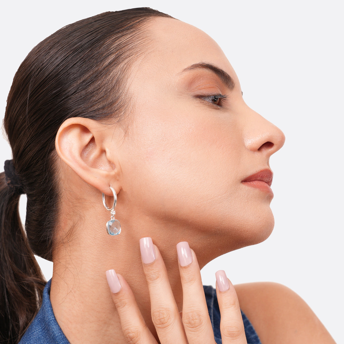 Model resting her fingers beneath her jaw while wearing a sterling silver hoop earring with a pale aqua chalcedony drop.