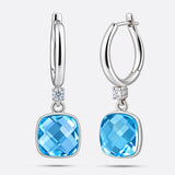 Front and side views of the silver drop hoop earrings, showing the faceted aqua chalcedony and the thickness of its setting.