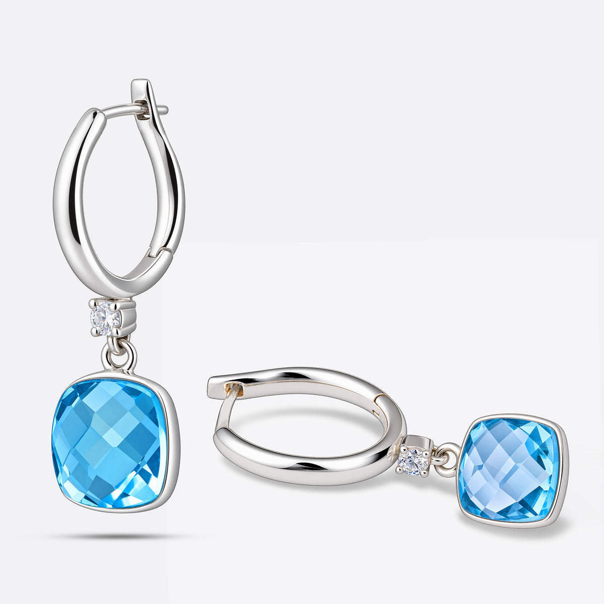 Two aqua chalcedony drop hoop earrings in sterling silver, one standing upright and the other laid flat to show its profile.