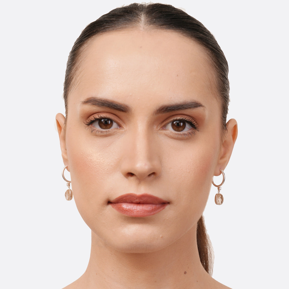 Model wearing RILAVE golden rutilated quartz drop hoop earrings in sterling silver, viewed from the front.