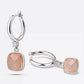 Pair of golden rutilated quartz drop hoop earrings in sterling silver, one upright and one resting on its side.