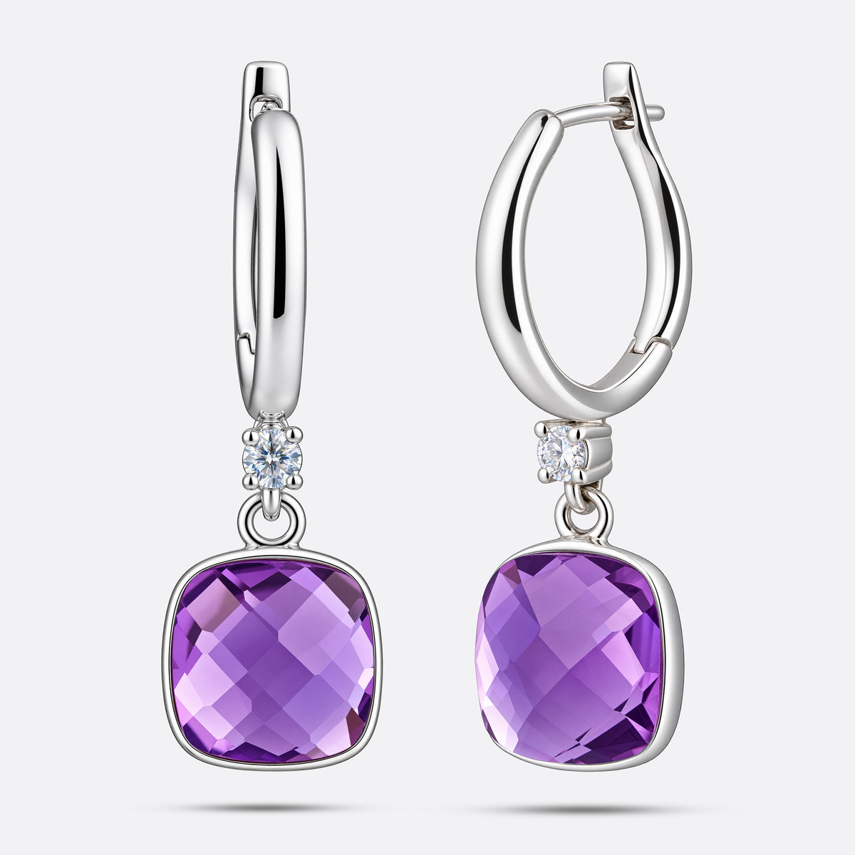 An angled view of two silver drop hoop earrings, showing the faceted surface of the cushion-cut violet amethyst centrepieces.