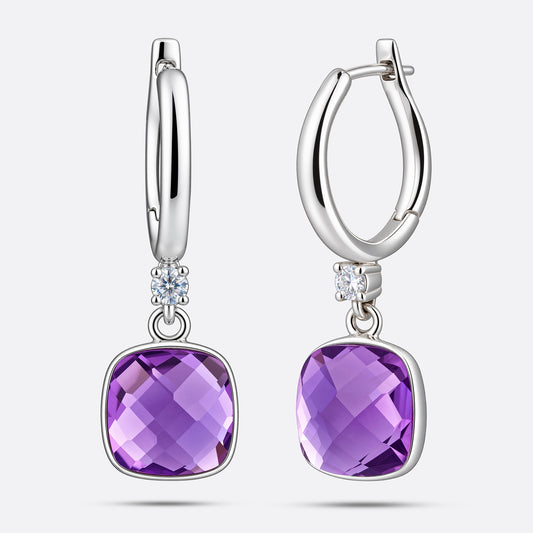 An angled view of two silver drop hoop earrings, showing the faceted surface of the cushion-cut violet amethyst centrepieces.
