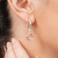 Detailed view of a silver drop hoop earring worn by a model, showcasing the polished sterling silver finish and White Topaz gem.