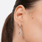 Side view of a Green Amethyst drop hoop earring worn by a model, with a faceted stone hanging below a polished silver hoop.
