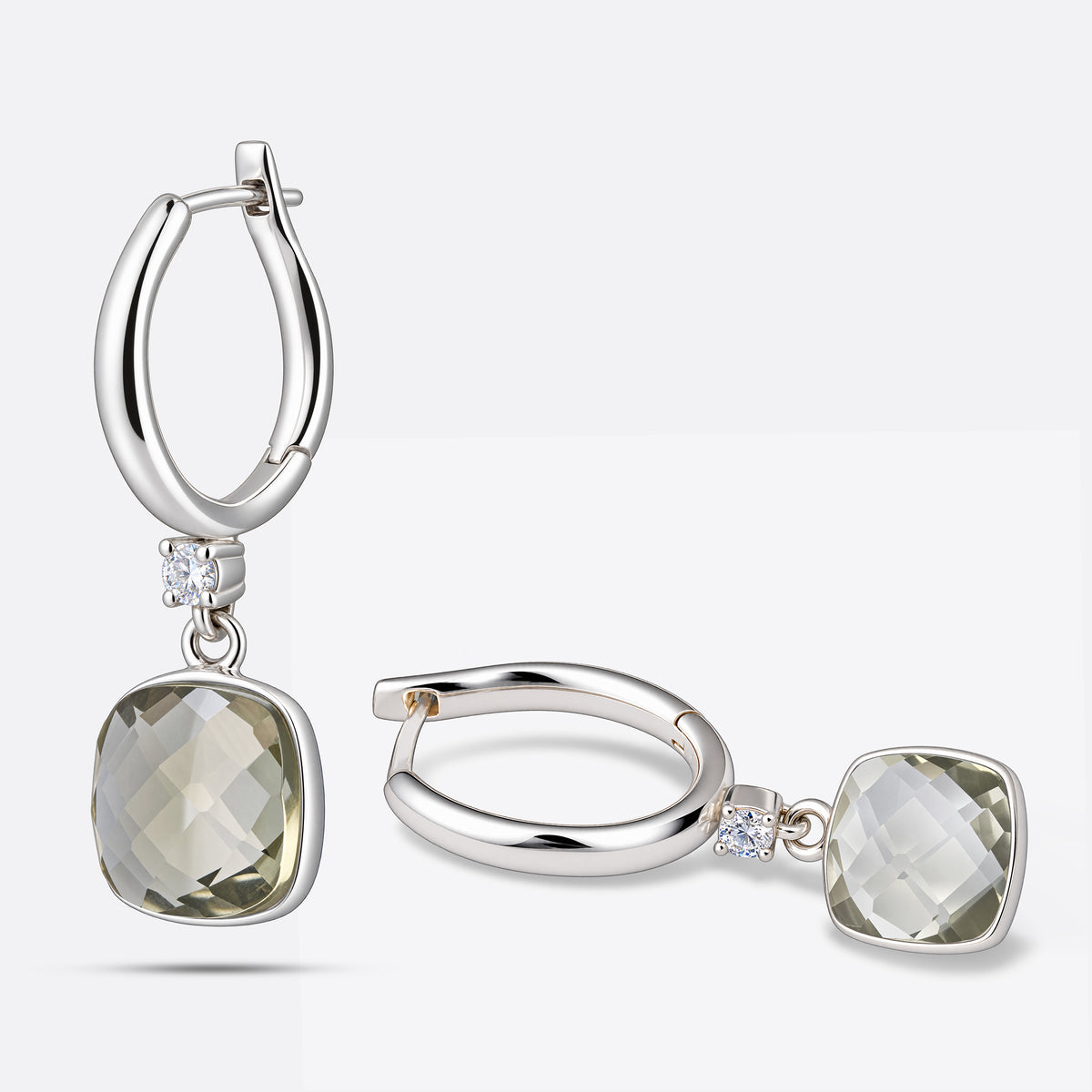 Green Amethyst drop hoop earrings arranged upright and sideways, showing their pale green stones, silver hoops and clear accents.
