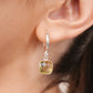 Close-up of a Lemon Quartz drop hoop earring worn on the ear, showing the polished silver hoop and faceted yellow gemstone.