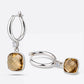 Two Olive Quartz drop hoop earrings arranged upright and on their side, revealing the cushion-cut stones and silver hoops.