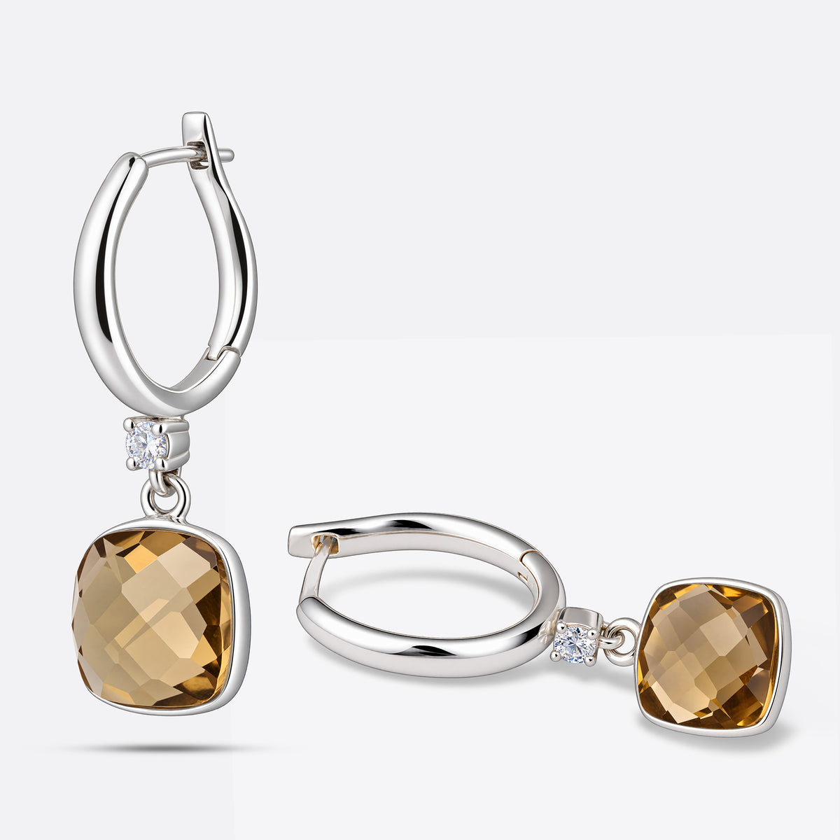 Two Olive Quartz drop hoop earrings arranged upright and on their side, revealing the cushion-cut stones and silver hoops.