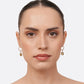 Model wearing RILAVE Olive Quartz drop hoop earrings, with faceted golden-brown gemstones suspended from silver hoops.