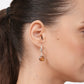 Side profile of a model wearing a RILAVE Olive Quartz drop hoop earring, showing the cushion-shaped gemstone and silver hoop.