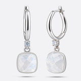 RILAVE Rainbow Moonstone drop hoop earrings in sterling silver, showing faceted cushion-shaped stones and an open hinged hoop.