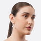 Model in three-quarter view wearing a silver Rainbow Moonstone drop hoop earring, with a soft blue flash visible in the stone.