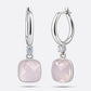 RILAVE Lumi Rose Quartz drop hoop earrings shown from the front and at an angle, with faceted pink stones and clear accents.