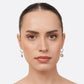 Model facing forwards wearing RILAVE Rose Quartz drop hoop earrings, with pale pink gemstones suspended beneath silver hoops.