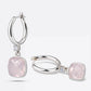 Pair of RILAVE Rose Quartz drop hoop earrings arranged upright and sideways, showing pale pink gemstones and polished silver hoops.